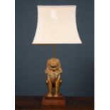An adjustable gilt metal temple lion table lamp, the lion sat on two tier wooden base beneath a