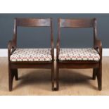 A pair of arts and crafts style oak framed armchairs the open backs over solid seats with