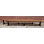 A pair of Victorian oak long benches with shaped supports united by stretchers, 340cm long x 44cm