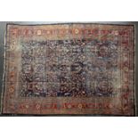 A Persian blue and red ground rug with a multiple banded border and stylised foliate decoration,