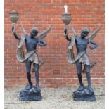 A pair of black and gold painted bronze torcheres, formed as winged figures each holding a torch and