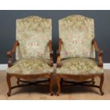 A pair of carved walnut framed open armchairs with green floral embroidered upholstery, on