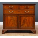 A mid 19th century mahogany cabinet with two short and one long drawer over twin panel cupboard