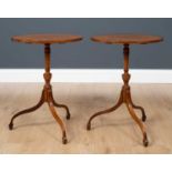 A pair of George III style mahogany tripod tables, on turned column and three outswept supports,