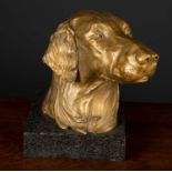 A gilt wooden carved statue of a golden retriever's head, at a three-quarters angle on a black