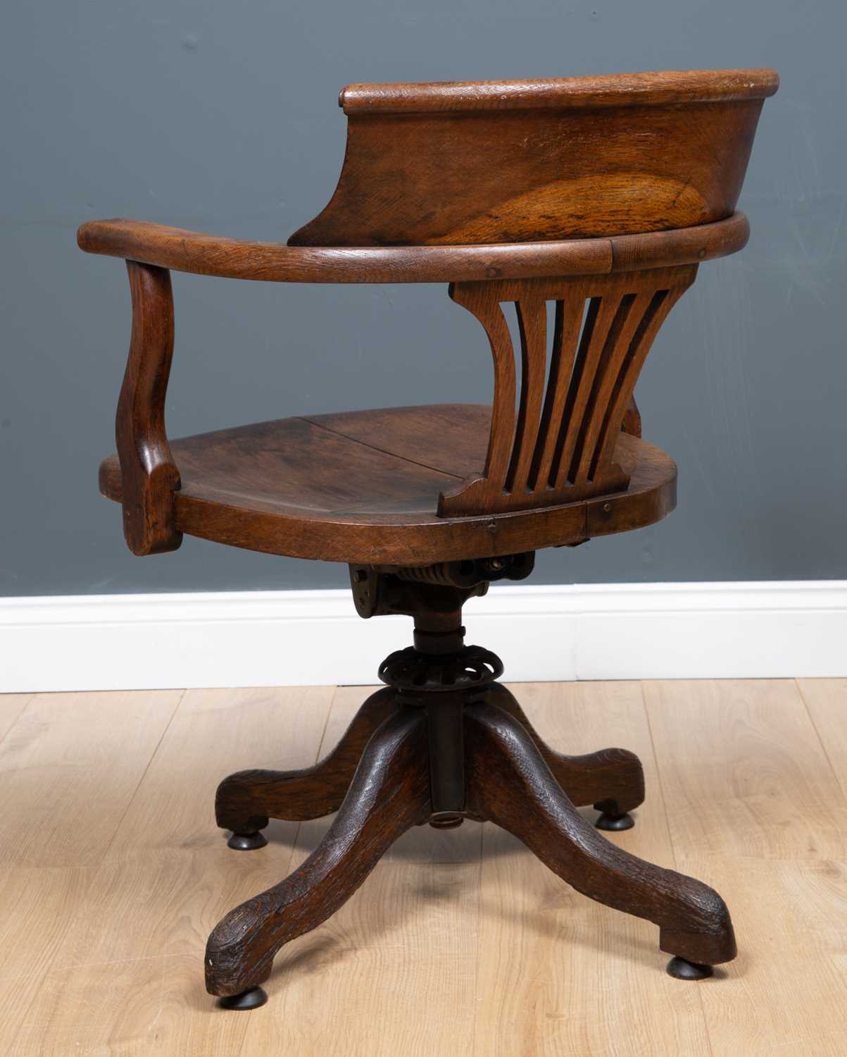 An Edwardian oak swivel desk chair with open arms on outswept supports, 58cm wide x 52cm deep. - Image 2 of 3