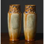 A pair of Royal Doulton stoneware tall vases, with relief abstract motif around the neck above
