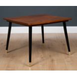 A 20th century rectangular coffee table, the mahogany top on outswept tapered black lacquer supports