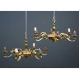 A pair of brass six branch chandeliers, the scrolled arms radiating from a central circular dish,