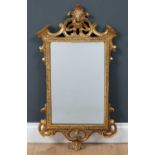 A Georgian-style giltwood carved mirror, the rectangular mirror plate in carved frame with scroll