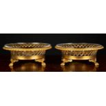 A pair of 19th century glass sweetmeat dishes on ormolu stands, the fretwork basket on three claw