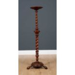 An 18th century yew wood torchiere with circular dish top, barley twist column supports and circular