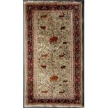 An Eastern pale green ground rug with a banded border, stylised foliate decoration and animal