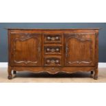An 18th century French chestnut enfilade with carved decoration to the three drawers and twin