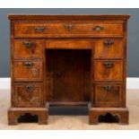 A George II walnut and featherbanded kneehole desk, with seven drawers about the knee and central