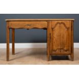 A French oak desk with single drawer and cupboard enclosing three drawers within and also with slide