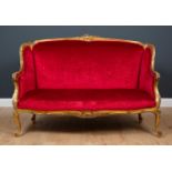 A 19th century French style gilt framed small sofa with carved ornament and overstuffed upholstery