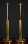 A pair of circular brass table lamps with fluted columns and circular bases, 59cm high to the