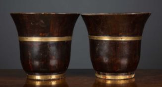 A pair of stained softwood turned waste paper baskets with brass bindings and flared rims, each 26.