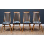 A set of four 1970's Ercol light elm and beech stick back dining chairs, on four outswept supports