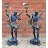 A pair of black and gold painted bronze torcheres, formed as winged figures each holding a torch and