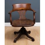 An Edwardian oak swivel desk chair with open arms on outswept supports, 58cm wide x 52cm deep.
