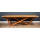 A contemporary pine dining table, the five plank top with perimeter crossbanding, on pine asymmetric