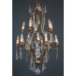 A French gilt metal chandelier, with two layers of candle-style sconces around central cut glass
