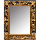 An ornate giltwood and gesso Venetian-style wall mirror, with foliate and scrolling edges, 67cm wide