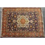 A dark blue ground Eastern rug with yellow and red decoration, a foliate motif to the centre with