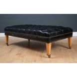 A contemporary rectangular low black leather button upholstered stool with square tapering beechwood