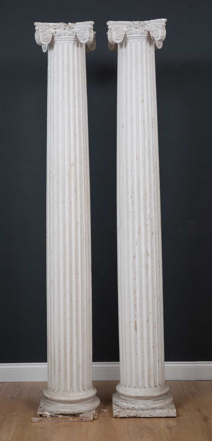 A pair of 19th century white painted tapered fluted plaster columns on plinth bases with Ionic