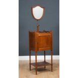 An Edwardian mahogany shaving stand with shield shaped adjustable mirror, above cupboard and low