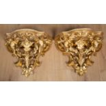 A pair of 19th century continental gilt carved wood wall brackets decorated with cherubs