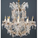 A chandelier or electrolier of ten lights with glass encased scrolling arms and swags of drops,