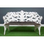 A white painted fern and blackberry pattern garden bench, the tub back frame enclosing a slatted