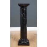 A black marble pedestal on a column with turned base and square plinth, 24cm x 24cm x 90cm