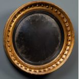 A Regency circular giltwood convex wall mirror, the carved frame with beaded decoration and