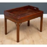 A 19th century mahogany butler's tray with galleries sides, pierced handles and on a later low