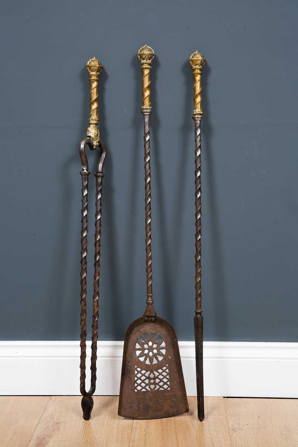 A set of 19th century brass and steel fire irons with pierced shovel, ribbon twisted stems and