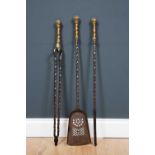 A set of 19th century brass and steel fire irons with pierced shovel, ribbon twisted stems and