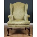 A late 19th century Georgian style green upholstered wingback armchair with carved cabriole front