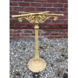 A yellow painted cast iron table base with mythical birds to the bracketed supports, 56cm wide x