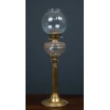 A 19th century brass oil lamp converted to a table lamp, the glass body beneath sphere top supported