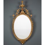 A Georgian-style giltwood mirror, the oval mirror plate in moulded frame with urn and flower spray