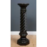 A black and green speckled marble classical style column, the circular pedestal on fluted spiral