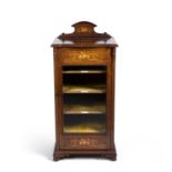 An Edwardian rosewood and inlaid music cabinet, the glazed and hinged door enclosing five shelves,