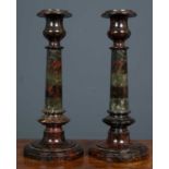 A pair of serpentine marble candlesticks each formed as an octagonal column on a turned base, 13cm