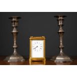 A pair of silver candlesticks, Sheffield, 20cm high together with a brass carriage clock, the