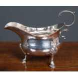 A George III silver cream jug by John Lambe, with scrolling handle and hoof feet, owners initials '